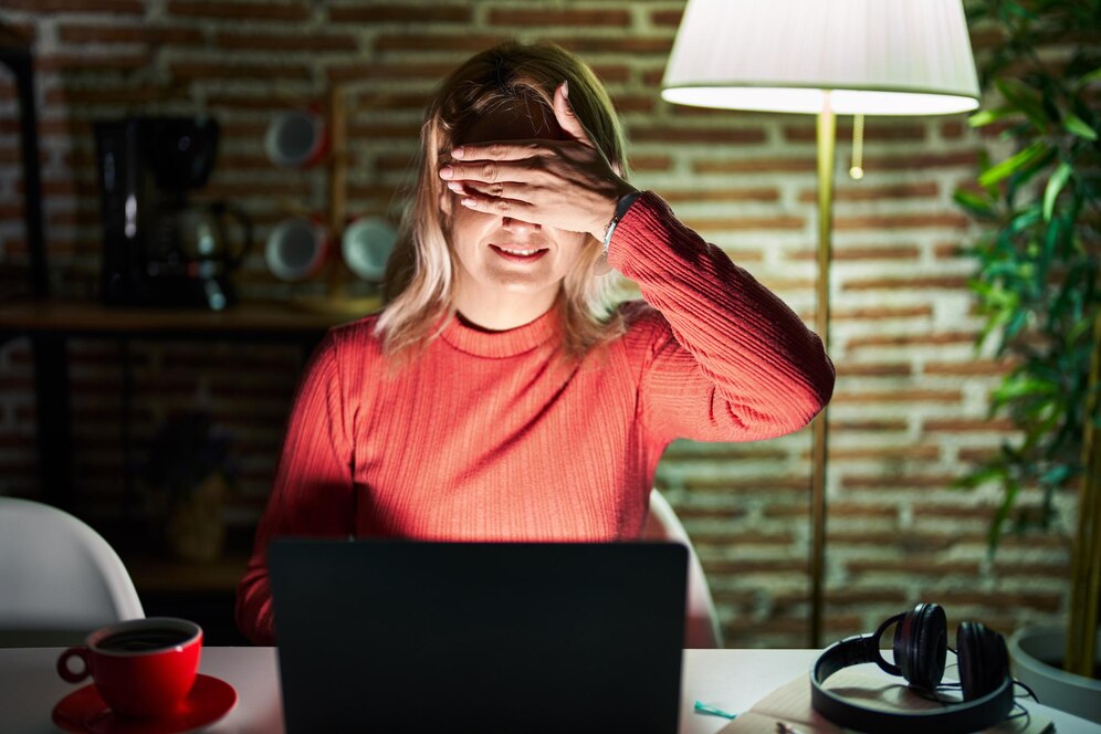 blonde-woman-using-laptop-night-home-smiling-laughing-with-hand-face-covering-eyes-surprise-blind-concept_839833-4840.jpg