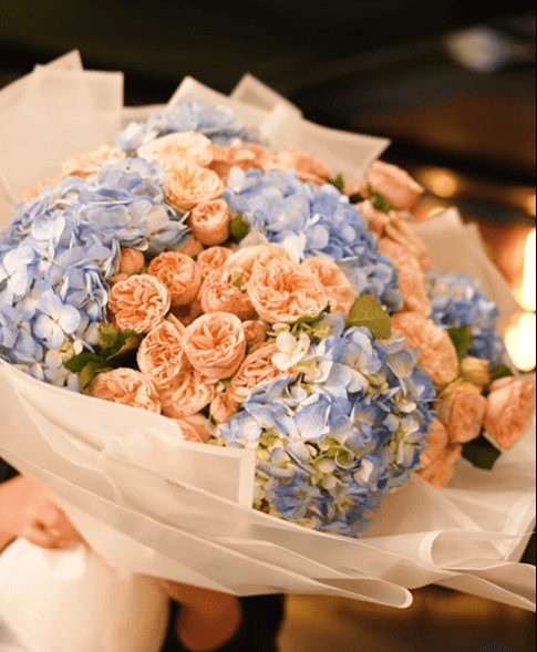 Букет из бело-голубых гортензий и персиковых спрей-роз