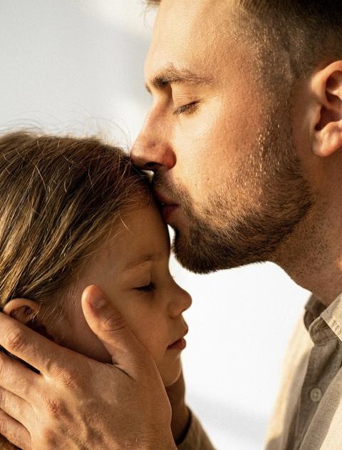 Создай портрет, не меняя черты лица. Кинематографический эффект с добавлением зерна Ультрареалистичный экстремально крупный план части лица ребенка и мужчины, ребенка  часть лица и часть лица мужчины , фото залито солнечным светом Не меняй черты лица Фото в золотой час
Фон белый 
Мужчина с закрытыми глазами целует ребенка  в лоб держа лицо его руками 
ребенок  с закрытыми глазами 
Они боком к камере . на них бежевая одежда 
Макро портрет
Фото в теплых оттенках
Не меняй черты лица