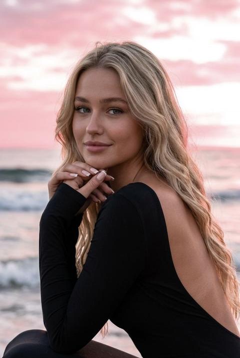 Создай крупный макро по пояс портрет, не меняя черты лица.
Портрет женщины в полу профиль, сидящую на берегу океана, на красивом розовом закате. Она одета в черное  платье с открытой спиной и длинными рукавами по фигуре у неё  волнистые  волосы, безупречный макияж, лёгкий загар, она смотрит в камеру с легкой улыбкой. Ее руки сцеплены в замок у подбородка. Маникюр нюдовый квадратный .
Освещение мягкое, розовый закат создающее кинематографичную. Высокая детализация текстуры кожи. Ключевые параметры для настройки:
Стиль: Фотореализм, Cinematic Lighting (кинематографичный свет).
Цветовая гамма: контрастные тона, преобладание белого, розового