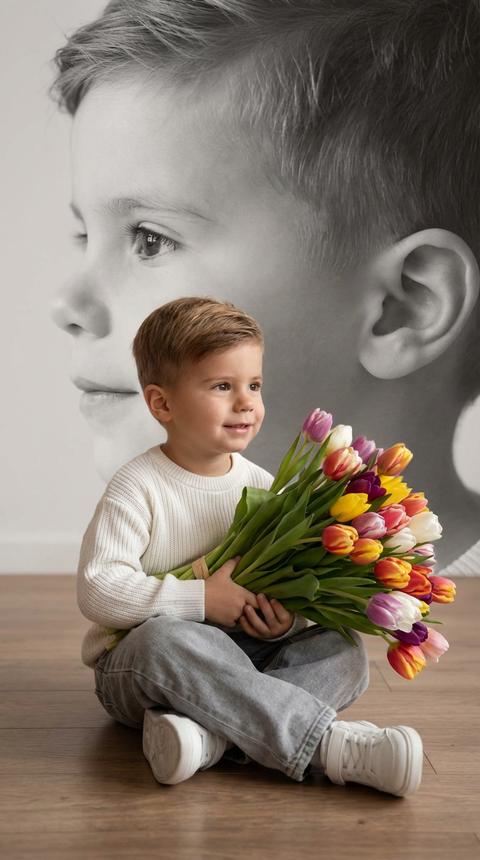 Создай портрет, не меняя черты лица, и превратите его в художественный портрет.
Ребенок мальчик , сидит на полу в изящной позе, в белой кофте, мягких свободных серых джинсах и белых спортивных кроссовках. Он держит в руках огромный букет ярких разноцветных тюльпанов
Выражение лица — лёгкая улыбка, он смотрит в сторону. Фон — тот же его профиль, в мягком крупном чёрно-белом художественном стиле, крупный план сбоку. Композиция должна быть художественной, мягкой, реалистичной. Создай изображение, которое выглядит как настоящая фотография. Формат 9:16. Не меняй черты лица».