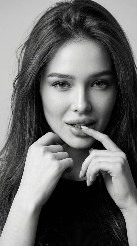 СТРОГО СОХРАНИ ВНЕШНОСТЬ девушки с прикреплённого селфи, сохранив 1:1 её настоящее лицо, глаза, нос, губы, кожу с текстурой, волосы, пропорции - всё 100% без изменений. Ультра-реалистичное чёрно-белое портретное фото (кадр по плечи), волосы красиво уложены. Поза точно: голова слегка наклонена, сексуальное выражение лица, хитрый взгляд прямо в камеру. указательный палец у нижней губы. Образ точно: чёрный топ у шеи виден слегка.
Фон: чистый однотонный светло-серый, слегка размытый. Свет: мягкое высококонтрастное студийное чёрно-белое освещение с глубокими тенями и яркими бликами на коже, губах и волосах.
Фотореализм 8K, максимальная детализация текстуры кожи, волос и глаз, классическая гламурная атмосфера. Формат 9:16 СТРОГО СОХРАНИ ВНЕШНОСТЬ девушки с прикреплённого селфи, сохранив 1:1 её настоящее лицо, глаза, нос, губы, кожу с текстурой, волосы, пропорции - всё 100% без изменений. Ультра-реалистичное чёрно-белое портретное фото (кадр по плечи), волосы красиво уложены. Поза точно: голова слегка наклонена, сексуальное выражение лица, хитрый взгляд прямо в камеру. указательный палец у нижней губы. Образ точно: чёрный топ у шеи виден слегка.
Фон: чистый однотонный светло-серый, слегка размытый. Свет: мягкое высококонтрастное студийное чёрно-белое освещение с глубокими тенями и яркими бликами на коже, губах и волосах.
Фотореализм 8K, максимальная детализация текстуры кожи, волос и глаз, классическая гламурная атмосфера. Формат 9:16