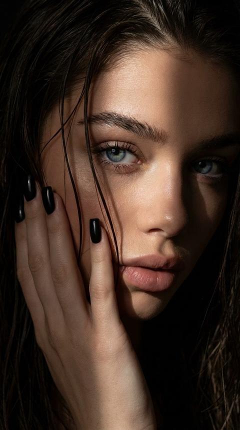 Экстремально крупный план лица
Портрет женщины, где контраст света и тени создают загадочную атмосферу.
Вокруг темно Она держит руку на лице Лицо освещено узкой полосой света, подчеркивающей скулы, острый нос и выразительные брови. Она смотрит уверенно, с дерзким взглядом. Волосы мокрые прилипают частично к лицу. У неё средние квадратные чёрные ногти. Пальцы изящные длинные. Нижняя часть тела скрыта, внимание сосредоточено на лице и руках.
Контрастное освещение, кинематографичный стиль с высоким качеством и детализацией.
Качество 8K
Ресницы накрашенные
Фото 9:16