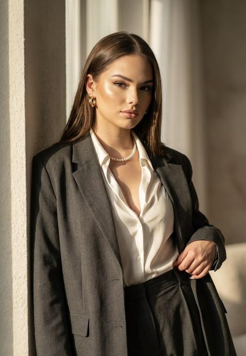 Экстремально детализированный портрет женщины в стиле raw с размытым фоном и мягким светом, акцентированным на её лице и костюме. Она стоит у стены, облокотившись спиной, расслабленная и уверенная в себе. Солнечный свет падает через окно, создавая теплое, золотистое освещение, подчеркивающее текстуру её темно серого оверсайз костюма. Костюм свободно облегает её фигуру, с лёгкими складками, создающими ощущение лёгкости.
Её поза спокойная, одна рука лежит вдоль тела, а другая слегка приподнимает пиджак. Белая шелковистая блуза с глубоким вырезом добавляет элегантности. Женщина носит золотые серьги и перламутровое колье, которые блестят в лучах солнца.
Лицо выражает спокойствие и уверенность, взгляд расслаблен, но с намеком на загадочность. Тёплый солнечный свет создаёт мягкие тени на её лице, акцентируя скулы и линии. Яркие глаза, наполненные спокойной решимостью, смотрят прямо в объектив. Волосы блестящие аккуратно уложены, и свет играет на их текстуре, добавляя образу лёгкости.
Солнечный свет с окна обвивает её
Кожа в хайлайтере
Качество 8К Экстремально детализированный портрет женщины в стиле raw с размытым фоном и мягким светом, акцентированным на её лице и костюме. Она стоит у стены, облокотившись спиной, расслабленная и уверенная в себе. Солнечный свет падает через окно, создавая теплое, золотистое освещение, подчеркивающее текстуру её темно серого оверсайз костюма. Костюм свободно облегает её фигуру, с лёгкими складками, создающими ощущение лёгкости.
Её поза спокойная, одна рука лежит вдоль тела, а другая слегка приподнимает пиджак. Белая шелковистая блуза с глубоким вырезом добавляет элегантности. Женщина носит золотые серьги и перламутровое колье, которые блестят в лучах солнца.
Лицо выражает спокойствие и уверенность, взгляд расслаблен, но с намеком на загадочность. Тёплый солнечный свет создаёт мягкие тени на её лице, акцентируя скулы и линии. Яркие глаза, наполненные спокойной решимостью, смотрят прямо в объектив. Волосы блестящие аккуратно уложены, и свет играет на их текстуре, добавляя образу лёгкости.
Солнечный свет с окна обвивает её
Кожа в хайлайтере
Качество 8К