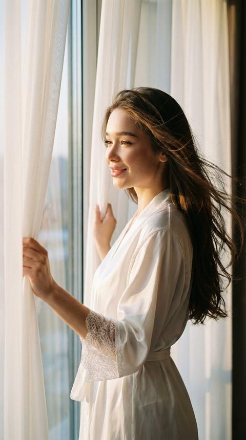 Не меняй черты лица. Крупный close-up девушки Она открывает двумя руками шторы утром у окна Ветер растрёпывает её длинные блестящие волосы, одета в белый шелковый халат с белым кружевом. Фото в золотой час Девушка не смотрит в камеру Атмосфера интимная,кинематографичная,эмоциональная.Высокая детализация кожи,натуральная текстура,мягкие тени и приглушённые хайлайты.
Плёночный эффект с выраженным зерном,матовые тени,обработка в стиле Kodak Portra 400.Съёмка на 85mm в модном editorial-стиле.
У неё легкая улыбка
Кожа идеальная Не меняй черты лица. Крупный close-up девушки Она открывает двумя руками шторы утром у окна Ветер растрёпывает её длинные блестящие волосы, одета в белый шелковый халат с белым кружевом. Фото в золотой час Девушка не смотрит в камеру Атмосфера интимная,кинематографичная,эмоциональная.Высокая детализация кожи,натуральная текстура,мягкие тени и приглушённые хайлайты.
Плёночный эффект с выраженным зерном,матовые тени,обработка в стиле Kodak Portra 400.Съёмка на 85mm в модном editorial-стиле.
У неё легкая улыбка
Кожа идеальная
