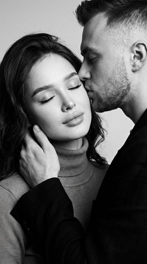 Создай портрет, не меняя черты лица. Крупный план, черно-белая фотография мужчины и женщины в интимный, нежный момент. Мужчина мягко целует женщину в щеку, его рука лежит на ее шее. Лицо женщины ровно без наклона направлено прямо к камере, с безупречным макияжем, глаза закрыты, выражение лица умиротворенное. Высокая детализация кожи, текстура , мягкое драматичное освещение, стиль пленочной фотографии, глубина резкости, эмоциональность.
Hyper-realistic skin texture, cinematic lighting, moody atmosphere, 35mm film grain, high contrast, emotional depth.