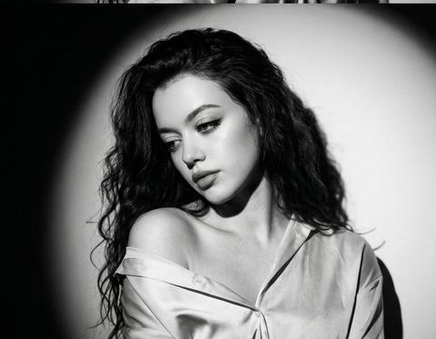 СТРОГО сохранить внешность 1:1
- Lo, epb,
пропорции, цвет и длину волос. Вертикальное изображение из двух чёрно-белых кадров один над другим вплотную, без разделителей, без зазора. Оба кадра - крупный портрет по грудь на фоне светлой стены. На девушке светлая атласная рубашка, спущенная с плеч. Волосы распущены, очень объёмные, крупные мягкие волны, большая прядь закрывает один глаз. Очень жёсткий направленный белый свет сбоку сверху, узкий spot light, пересвеченный центр круга на стене, резкий край света, вокруг глубокая проваленная тень, экстремальный контраст, crushed blacks, no fill light, сильная недоэкспозиция. Снято на full-frame camera, 85mm lens, f/2.0, ISO 50, shutter 1/250, exposure
- ﻿1.3 EV, hard shadow, high contrast. Верхний кадр: голова наклонена влево и чуть назад, взгляд вверх влево, правая рука выше. Нижний кадр: голова ниже к правому плечу, взгляд вниз влево, правая рука ниже.
