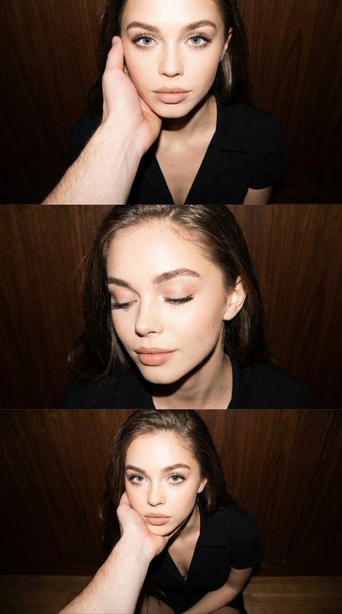 Триптих из трех панелей с изображением женщины и мужской руки. На каждой панели изображены разные позы и выражения лица на простом, нейтральном фоне. Верхняя панель представляет собой крупный план лица и верхней части груди женщины. Она смотрит прямо в камеру, голова слегка наклонена. Мужчина находится за кадром, видна только его рука. Большая рука мужчины обхватывает щеку и челюсть женщины с обеих сторон. Глаза женщины открыты и смотрят прямо в объектив. Камера снимает сверху вниз. Средняя панель — это крупный план. Лицо женщины слегка повернуто к камере на три четверти. Ее глаза закрыты. Ее рот расслаблен, едва заметная улыбка. Камера находится на уровне глаз. Нижняя панель — это средний план от головы до середины торса. Женщина сидит, опираясь подбородком на руку мужчины. Она смотрит прямо в камеру со спокойным, нейтральным выражением лица. Съемка ведется сверху вниз. На всех трех панелях естественный макияж с акцентом на глаза, ровный тон кожи с мягким матовым финишем, верхние ресницы удлинены и разделены черной тушью, а губы покрыты ровным слоем бежево-розовой помады. Волосы блестят от вспышки. Женщина одета в черное платье с V-образным вырезом и воротником, с длинными рукавами. Рука мужчины на верхней панели обнажена, со светлым оттенком кожи, видна часть предплечья. Действие на всех трех панелях происходит в помещении с плоскими темными деревянными панелями в качестве фона. Текстура дерева видна в виде вертикальных или горизонтальных досок от среднего до темно-коричневого оттенка. Фон размыт и идентичен на всех трех панелях для подчеркивания единообразия. Освещение на всех трех панелях: яркая прямая вспышка, жесткий фронтальный свет от камеры, расположенный близко к оси объектива, сильное фронтальное освещение, равномерно освещающее лицо и верхнюю часть тела, короткие, резкие тени под подбородком и немного позади женщины на стене, высокая контрастность с четкими бликами на коже и волосах, выраженные блики от вспышки в зрачках, минимальное фоновое заполнение. Высокодетализированный фотореалистичный снимок, сделанный на 35-мм объектив для всех трех панелей, малая глубина резкости с резким фокусом на лице, руке и верхней части тела женщины, слегка размытый деревянный фон с мягкой, но заметной текстурой, фотографический стиль, напоминающий прямую цифровую вспышечную фотографию для социальных сетей.