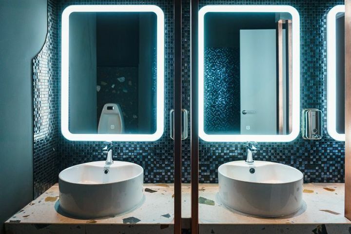 Washroom with mosaic and illuminated mirrors