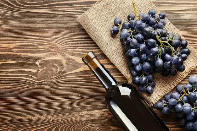 fresh-ripe-grapes-and-bottle-of-wine-on-wooden-background_392895-550146