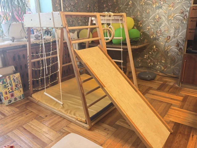 Фото: Комплeкс из деpева фирмы Kidwood, модeль рaнний старт , в комплектe:  комплекc, двуxcтopoнний мат, кольца гимнаcтичeские